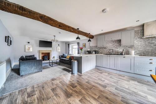 a kitchen and living room with white cabinets at Cosy Apartment above Village Pub in Buxton