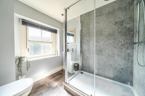 a bathroom with a shower and a toilet at Cosy Apartment above Village Pub in Buxton