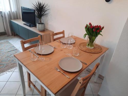 a wooden table with wine glasses and a vase of flowers at Ferienwohnung No15 in Pfullendorf