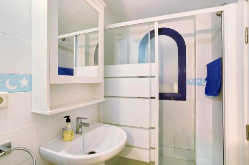 a white bathroom with a sink and a shower at Meloneras 1 in Maspalomas