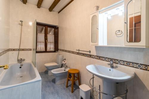 a bathroom with a sink and a tub and a toilet at Casa Rural Perullé in San Vicente de la Barquera