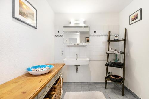 a bathroom with a sink and a counter with a bowl on it at Wat'n Utkiek in Rodenäs