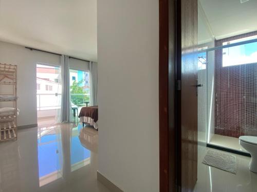 a bathroom with a toilet and a sink and a window at Requinte e Conforto na Praia do Morro in Guarapari