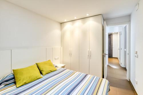 a bedroom with a bed with a yellow pillow at Villa La Vall in L'Escala