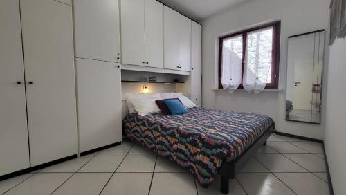 a bedroom with a bed and a window and white cabinets at Appartamento Bellavista in Capoliveri