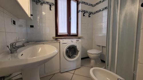 a bathroom with a washing machine and a sink at Appartamento Bellavista in Capoliveri