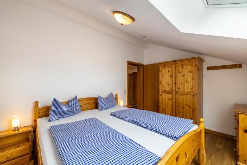 a bedroom with a bed with blue and white sheets at Fewo Brünnstein - Zimmer 65 in Oberaudorf