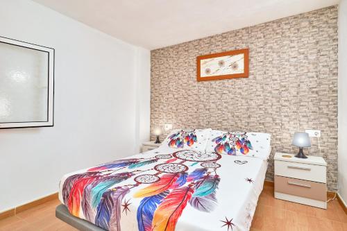 a bedroom with a bed with a colorful comforter at Naranja apartment in Nerja