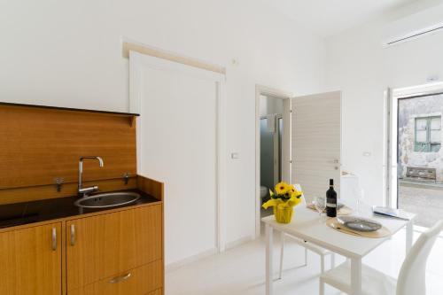 a kitchen with a white table and a sink at Casa Elaia 4 posti a Cannole in Cannole