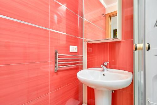 a red bathroom with a sink and a mirror at Naranja apartment in Nerja