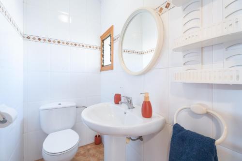 a white bathroom with a toilet and a sink at Casa del Practicant in Culla