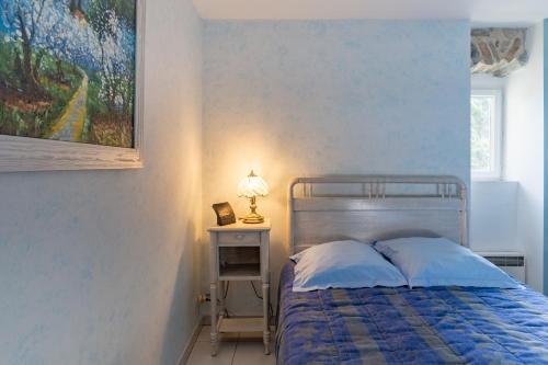a bedroom with a bed and a painting on the wall at Chez l'Oncle in Gras