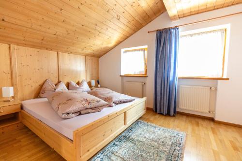 a bedroom with a bed with a wooden ceiling at Haus Simon in Nova Levante