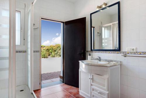 a white bathroom with a sink and a mirror at Villa Perez Zara Paco in Campano