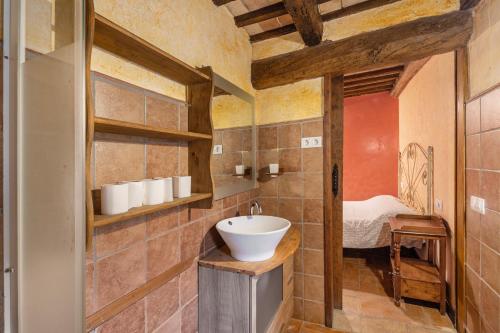 a bathroom with a sink and a bed in a room at Casa Subiraneta in Puigreig