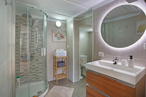 a bathroom with a sink and a shower and a mirror at Piscina Climatizada in La Hidalga