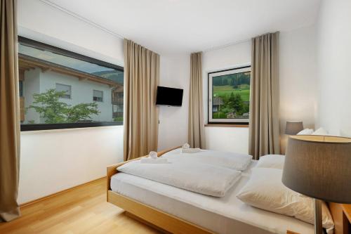 a bedroom with a bed and a large window at Premium App Hofer Maria in Villabassa