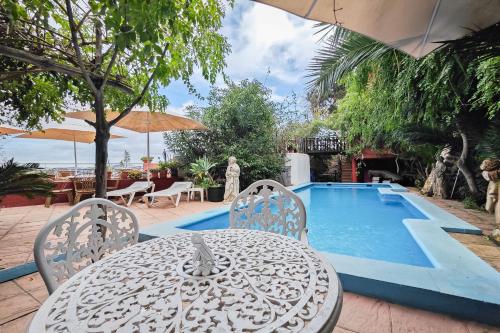 a table and chairs next to a swimming pool at Navila Estudio en la piscina in Ibiza Town