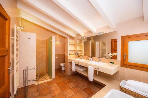 a bathroom with two sinks and a toilet and a mirror at Els Clepes in Son Servera