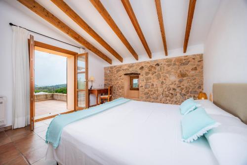 a bedroom with a white bed and a large window at Els Clepes in Son Servera
