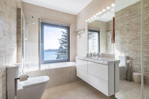 a bathroom with a sink toilet and a window at El Chiripero Beach Villa in A Coruña