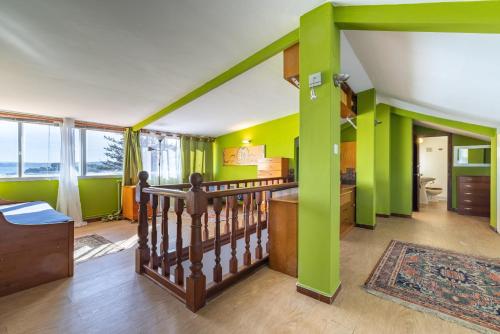 a living room with green walls and a staircase at El Chiripero Beach Villa in A Coruña