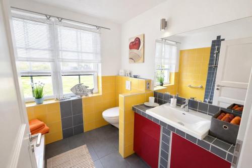 a bathroom with a sink and a toilet at Huus ant Kornfeld Erdgeschoss in Osteel