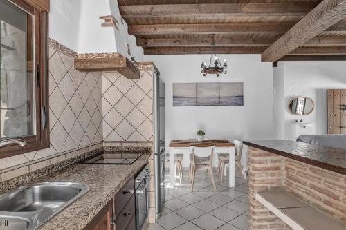 a kitchen with a sink and a table at Casas al Alba in Zahora