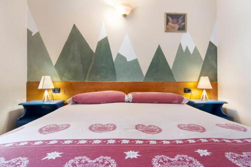 a bedroom with a large bed with two lamps at Residence Larice Bianco App n3 in Campodolcino