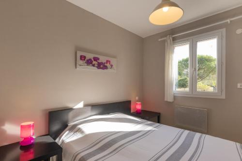 a bedroom with a bed with two pink candles at Gîte Chêne ou Murier in Les Vans