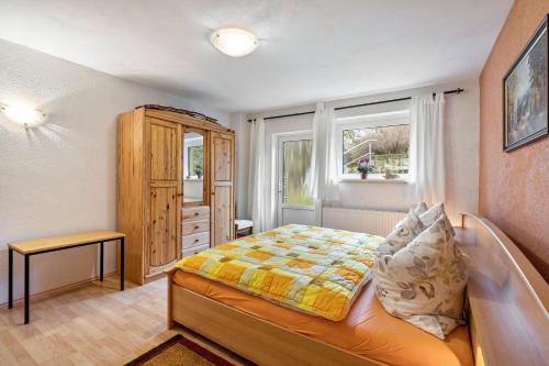 a bedroom with a bed and a wooden cabinet at Ferienwohnung Heidi in Bielatal