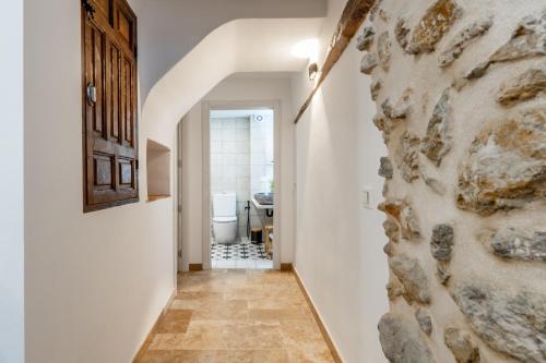 a hallway leading to a bathroom with a stone wall at Cueva Secreta Güejar in Güéjar-Sierra