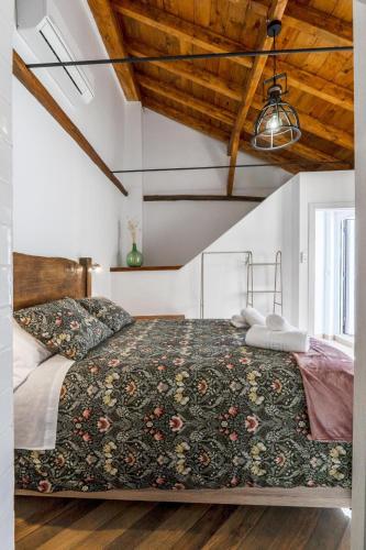 a bedroom with a large bed in a room with wooden ceilings at Cueva Secreta Güejar in Güéjar-Sierra