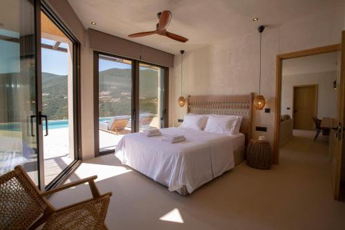 a bedroom with a white bed and a balcony at Villa Alexandra in Lefkada