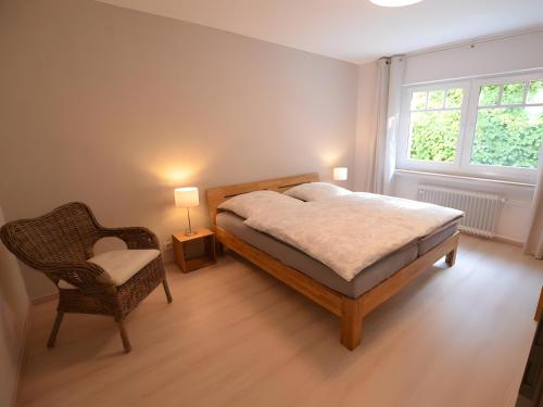 a bedroom with a bed and a chair and a window at Ferienwohnungen Ambiente-Schmidt in Olsberg