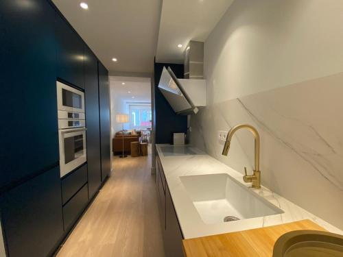 a kitchen with a sink and a stove at 'Socaire' Ribadesella in Ribadesella