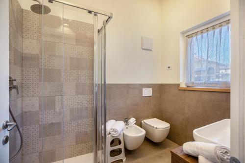 a bathroom with a shower and a toilet and a sink at Casa Penasa Appartamento 1 in Commezzadura