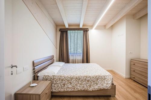 a bedroom with a bed and a window at Casa Penasa Appartamento 1 in Commezzadura