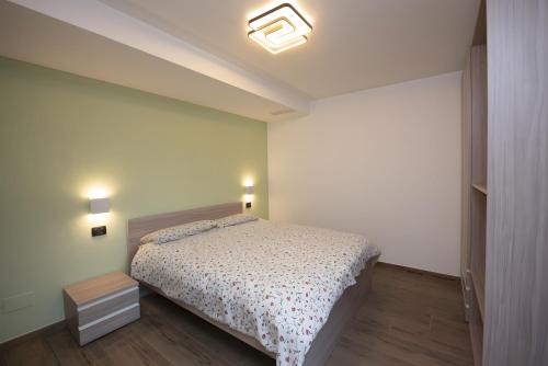 a bedroom with a bed and two lights on the wall at Appartamenti Suly 4 - Cir0085 in Saint Vincent