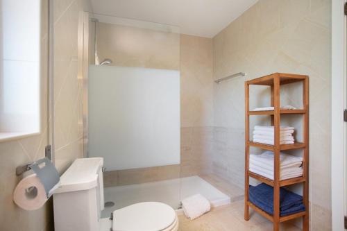 a bathroom with a shower and a toilet and towels at Foz Fancy Fun in Foz do Arelho
