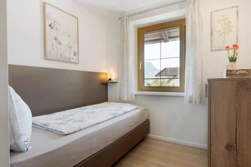a small bedroom with a bed and a window at Auelehof Laives in Laives