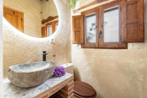 a bathroom with a stone sink and a mirror at El Kubo in Olba