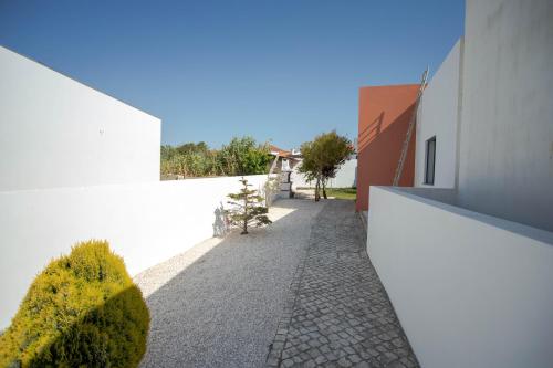 a walkway between two white buildings with plants at Forest Village Exótic in Bolembre de Baixo