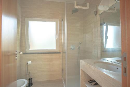 a bathroom with a glass shower and a sink at Forest Village Exótic in Bolembre de Baixo