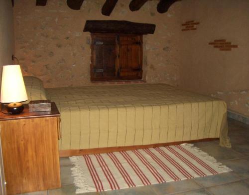 a bedroom with a bed and a table with a lamp at Casa Gimeno in Bocairent