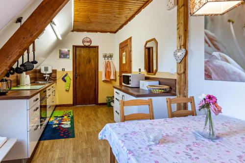 a kitchen with a table with a vase of flowers on it at La Rose in Tengen