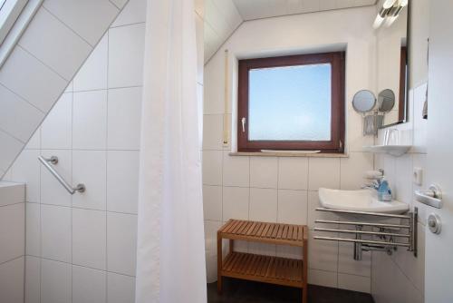 a white bathroom with a sink and a window at Gästehaus Heinemann - Dg4 in Langenargen