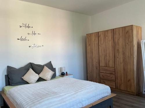 a bedroom with a bed and a wooden cabinet at Harzträume Thale in Thale