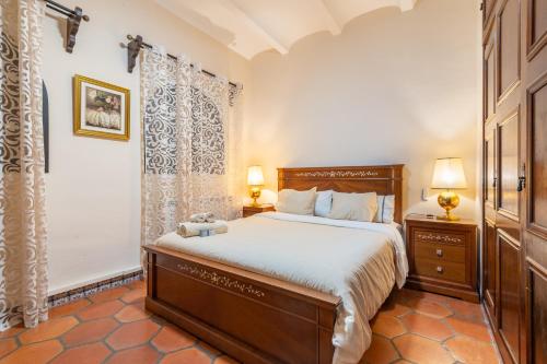 a bedroom with a bed and two lamps and a window at Petit Palau in Port de Soller