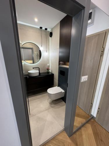a bathroom with a toilet and a mirror at Sofia Tech Park Apartments - Premium in Sofia